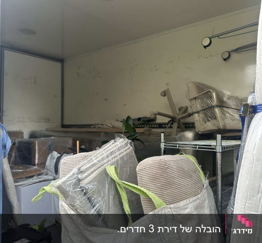 ריהוט, ציוד וארגזים ארוזים ומועמסים בתוך משאית הובלה